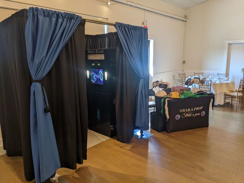 vintage enclosed photo booth at a wedding with a props table