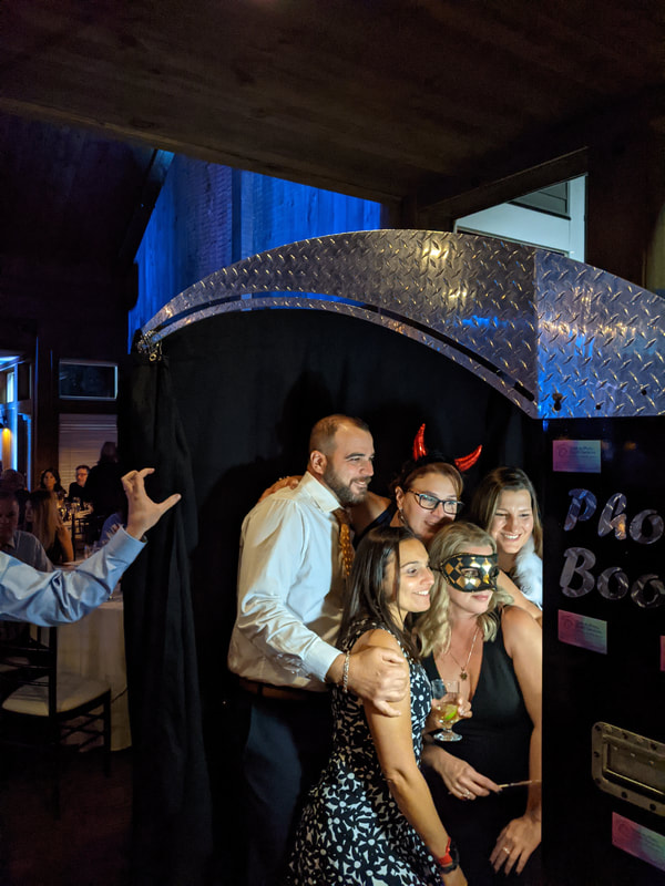People taking pictures in photo booth at wedding