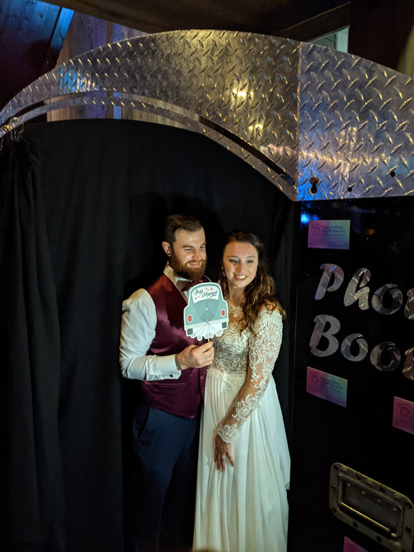 Bride and groom taking pictures in photo booth